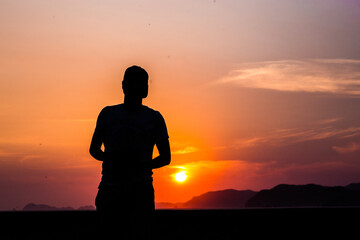 Hombre a contraluz en un atardecer naranja