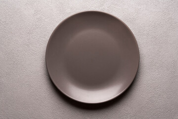 an empty brown plate on a gray table. minimalistic falt lay, mockop copyspace