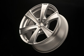 silver alloy wheel for crossovers and SUVs on a dark background, close-up