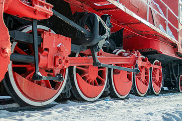 Red iron wheels from a steam locomotive. They stand on the rails.