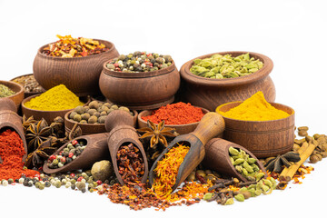 Assortment of spices  to wooden tableware by close up on a white background.