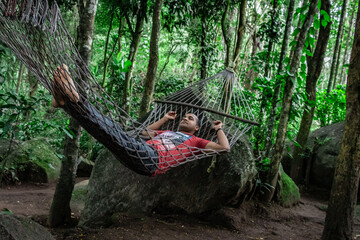 man isolated sleeping at hammock solo camping in deep green forests