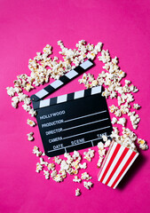 Movie clapperboard and popcorn on fuchsia pink background
Conceptual of cinema