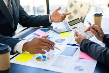 Hands of business people working in the office with documents That represents the investment results of the company Profits between companies that have made a mutual agreement