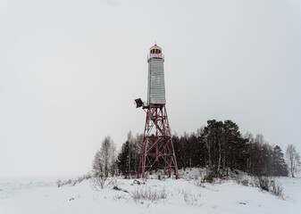 old abandoned lighthouse on the islands in Lake Onega, photo in winter.