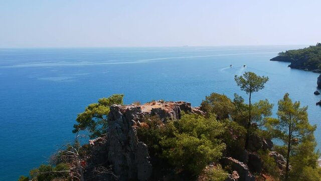 Morning on the beach in the village of Cirali, fishing nets lie on the yellow sand. Boats and ships in the distance of the Taurus mountain are moored near the shore. Landscapes of the Lycian Trail.