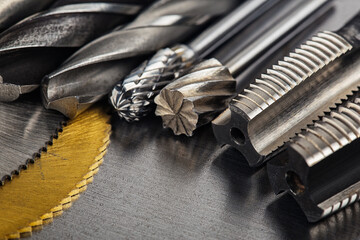 set of different drill bits,thread tap and mill cutters with caliper ruler on steel plate...