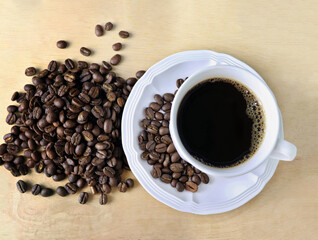 Coffee cup and Roasted coffee beans on Wooden floor. Top view photo.