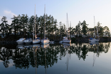 Boats reflected in the still water, Princess Bay, Wallace Island, Gulf Islands, British Columbia,...