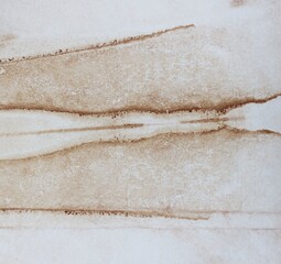 Seo-brown watercolor background. Transparent lines and spots on a white paper background. Horizontal lines. Paint leaks and ombre effects. Abstract hand-painted image. © Olirina