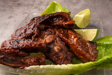 closeup of roasted pork ribs with barbecue sauce and caramelized with honey. Tasty homemade snack or small business ow