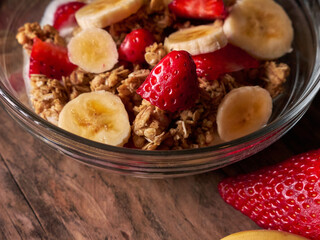 Bowl with cereals, strawberries and banana, close up look. Healthy eating concept.