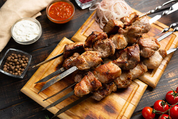 kebabs meat on metal skewer on cutting board rustic style