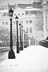 old style street lamps on a snowy Baker Street in London in black and white.