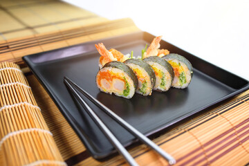 sushi roll on a black plate ready to be served