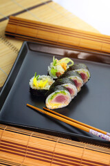 sushi roll on a black plate ready to be served