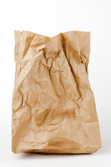 Crumpled paper bag with greasy spots on a white isolated background. Recycling of secondary waste