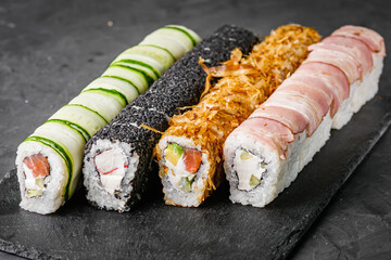 appetizing set of sushi roll on a black stone plate