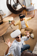 high angle view of african american kids gaming in vr headsets at home