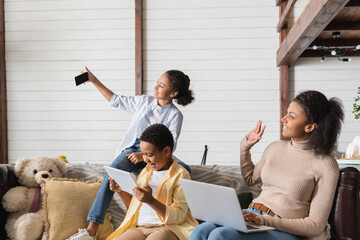african american girl taking selfie with family at home