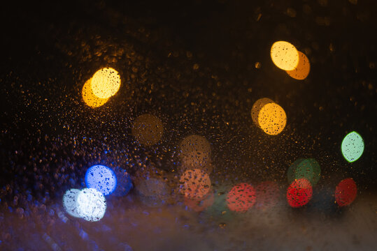 Blurred background with raindrops and lights. © Nikolay