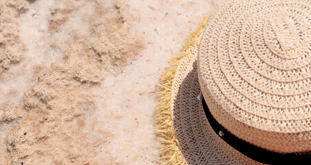 Fototapeta na wymiar a straw hat lies on the salty white sand. The concept of travel and recreation by the sea. Place for text. High quality photo