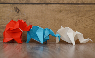 Leading colorful origami elephants on wooden