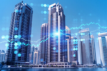 Fototapeta premium Skyscrapers of Dubai business downtown. International hub of trading and financial services of Western Asia. FOREX graph and chart concept. Double exposure. Dubai Canal waterfront.