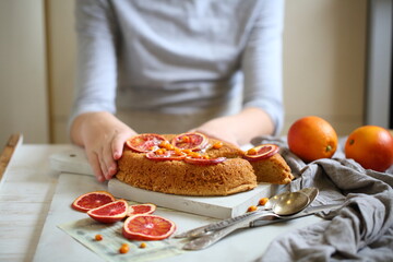 Children's hands decorate the orange pie