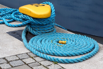 on the pier there is a bitteng with the number 22 and a blue rope wrapped around it side view
