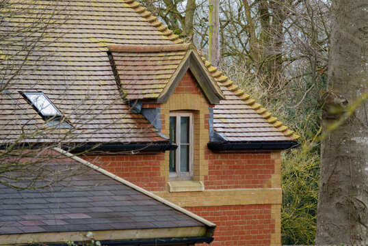 painted wooden dormer window in a brick house