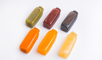Top view photo of fresh detox juice bottles over white background. Healthy style.
