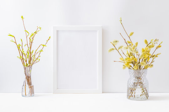 Home interior with easter decor. Mockup with a white frame and willow branches in a vase on a light background