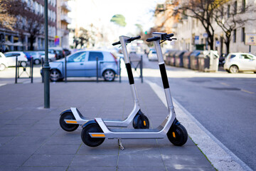Rental electric scooter parked on the side walk on a rainy day © Diego Maravilla