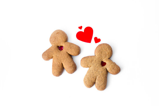 A pair of gingerbread lovers with hearts isolated on a white background. Christmas cookies with love. 