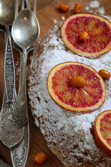 Sponge cake with red oranges on gray background
