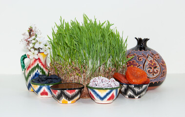 Happy background of the Navruz holiday. Celebration of Nowruz sweets and various dried fruits with green grass