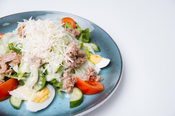 Close up photo of tasty fresh salad with ton eggs and grated cheese.