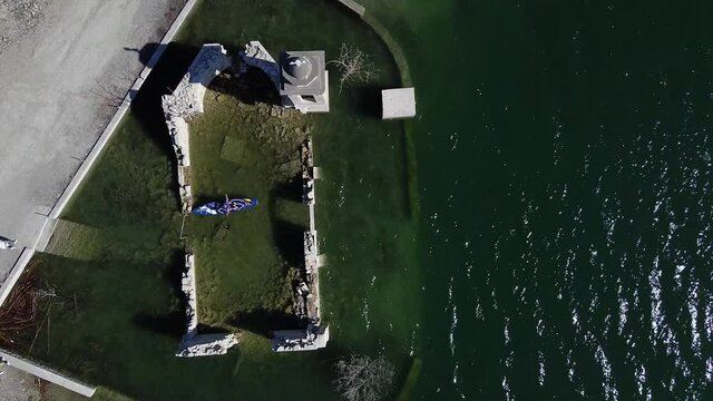 A paddleboarder explores the sunken ruins of the St. Nicholas Church inside the Kourris Dam, Cyprus.