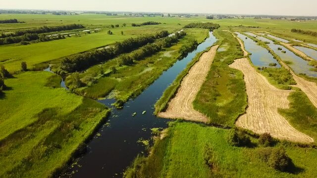 Aerial view of the Weerribben National Park, Overijssel, The Netherlands.
Dolly shot away from canal with boats and canoes.