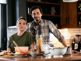 Fototapeta na wymiar Husband and wife in kitchen. Young couple preparing delicious food at home..