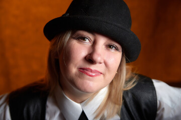 Portrait of fat plump chubby middle-aged woman with hat. Model posing in male style in the Studio.