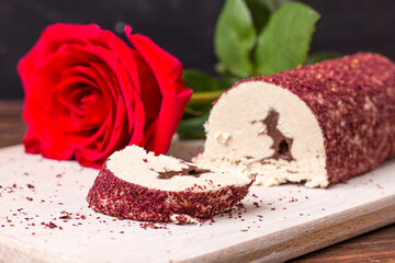 Eastern sweet halva with chocolate and rose powder on wooden background.