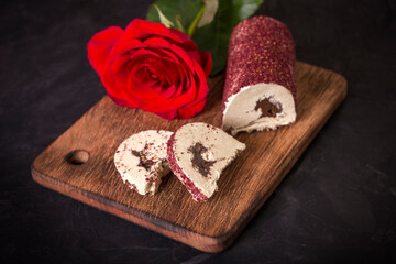 Eastern sweet halva with chocolate and rose powder on black background.