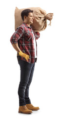 Full length profile shot of a young farmer carrying a sack on his shoulder