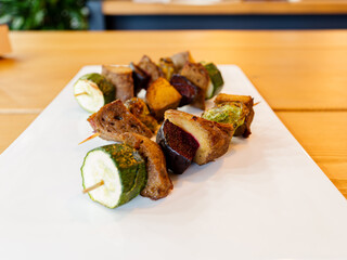 Vegan skewers with seitan and mixed vegetables on a grill