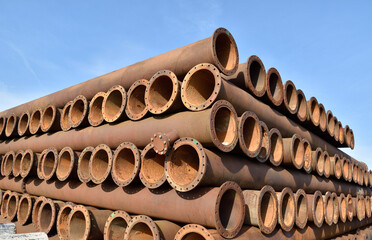 Stacks of metal pipes under the blue sky of a winter sun