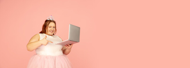 Flyer. Beautiful plump caucasian plus size model in fairy's outfit isolated on pink studio background. Concept of inclusion, human emotions, facial expression, sales, body positive. Copyspace for ad.