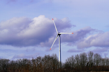 Windrad zur Energiegewinnung mit bewölktem Himmel.