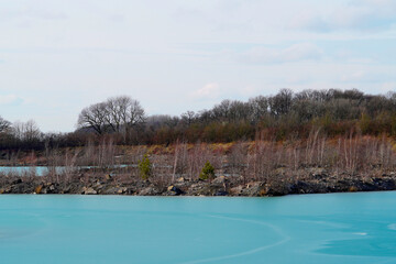 Blaue Lagune in Beckum, Nordrhein Westfalen. Gefrorener See, fotografiert im Winter bei sonnigem Wetter.
